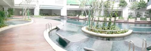 吉隆坡Verve 2Bedroom 2to6pax Kuala Lumpur near Midvalley MegaMall的一座有树木的建筑中的游泳池