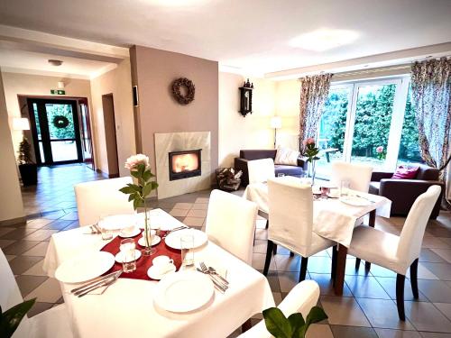 弗热希尼亚隆多宾馆的一间设有白色桌椅和壁炉的用餐室