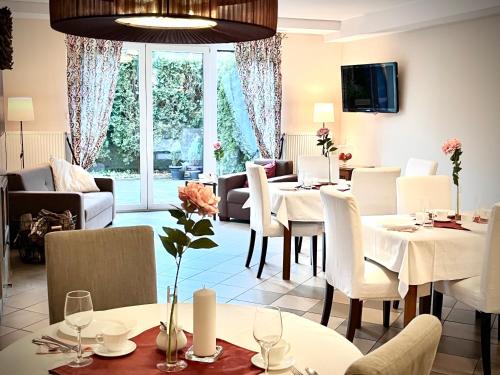 弗热希尼亚隆多宾馆的用餐室配有白色的桌子和白色的椅子