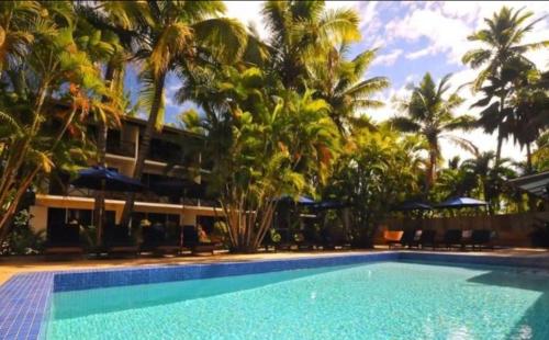 南迪Oasis Palms Hotel的棕榈树度假村前的游泳池