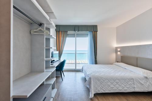 利尼亚诺萨比亚多罗哥伦布酒店的一间卧室配有一张床,享有海景