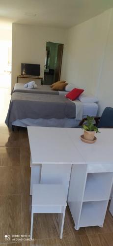 巴伊亚福尔莫萨Quarto Família - Com Suíte的一间卧室配有床和两张白色桌子