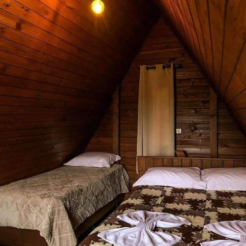 邦雅尔丁-达塞拉Chalés Altos Da Montanha- Everest的小木屋内一间卧室,配有两张床