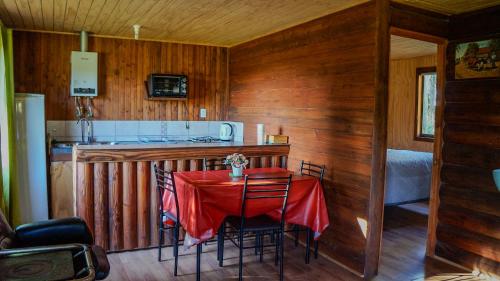 塔尔卡Cabañas Cerro Colorado Lago Colbún的厨房配有一张带红色桌布的桌子