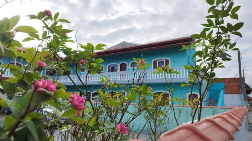 伊利亚孔普里达Apartamento dos Sonhos的蓝色和白色的房子,前面有鲜花