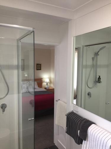 金德拜恩Wanderers Retreat的带淋浴和镜子的浴室以及一张床