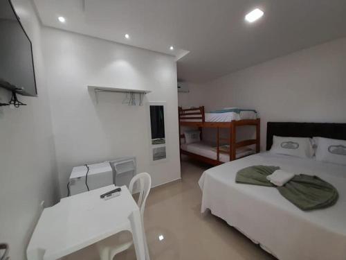 博阿维斯塔HOTEL CENTRAL MARGARITA的白色的客房配有两张床和电视。
