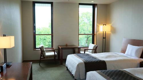 京都知恩院和顺会馆的酒店客房设有两张床、一张书桌和两个窗户。