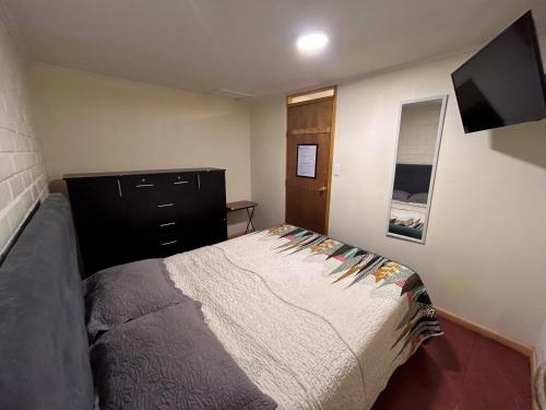 圣地亚哥Chez Humbert的一间卧室配有一张床和一台平面电视
