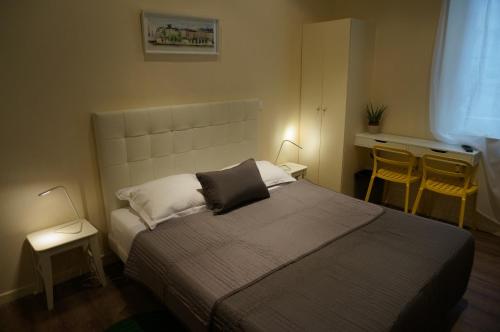 巴黎佐拉酒店的一间卧室配有一张带两张桌子和两盏灯的床。