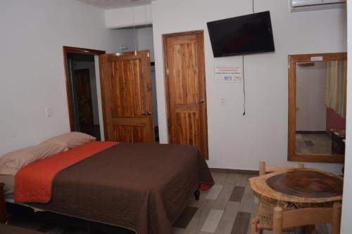 Ursulo GalvánEstancia Vacacional 20 Aguas的卧室配有一张床,墙上配有电视。