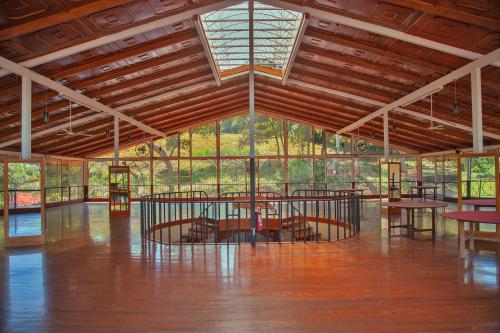 阿拉胡埃拉马蒂诺Spa及度假酒店的大型客房,铺有木地板,设有窗户和桌子。