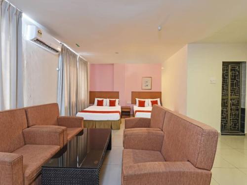 马六甲MRC Hotel Melaka Raya的酒店客房,设有两张床和一张沙发