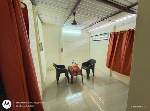 KottakupamKGP FARM STAY的一间房间,里面配有两把椅子和一张桌子