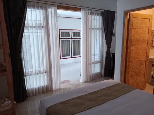 努沙杜瓦Manuh Guest House的一间卧室设有一张床和一个大窗户