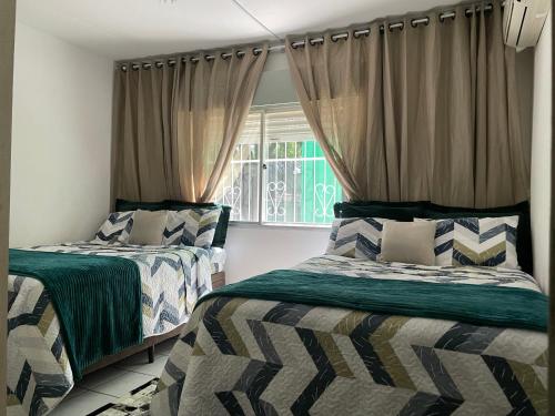 阿雷格里港Apartamento familiar com estacionamento的一间卧室设有两张床和窗户。