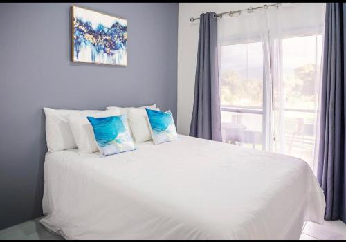 特拉Magic Beach para 6 personas frente al mar的卧室配有带枕头的白色床和窗户。