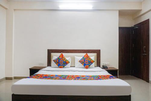浦那FabHotel Irish Koregaon Park的一间卧室配有一张带色彩缤纷枕头的大床