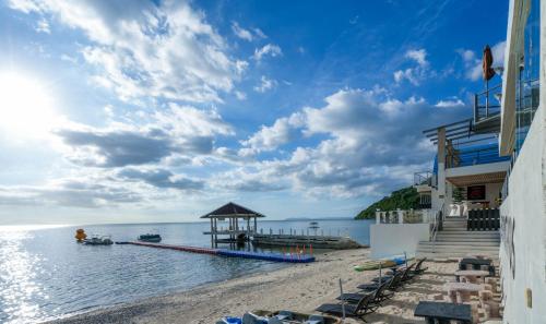 八打雁Destino Beach Resort and Hotel的一个带凉亭的海滩和大海