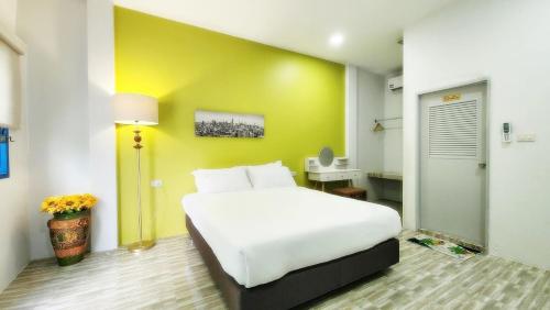 Ban Khuan Raeบ้านเพิงโฮมสเตย์的卧室配有白色的床和黄色的墙壁