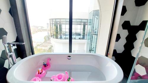 下龙湾Duplex 3 Bedroom Citadines Hạ Long - TDT Việt Nam的浴室设有浴缸,里面装有粉红色的填充动物