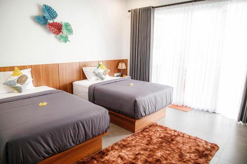 沙努尔Shanta Villa的酒店客房设有两张床和窗户。