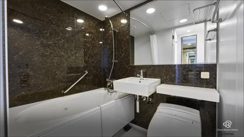 东京Daiwa Roynet Hotel Shimbashi的一间带水槽、卫生间和镜子的浴室