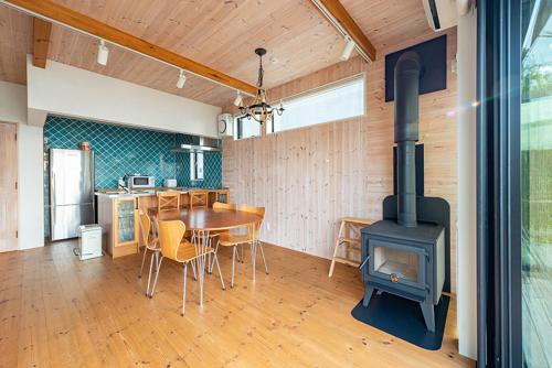 叶山町南葉山 - Seaside Cabin in Minami-hayama的厨房以及带燃木炉的用餐室。