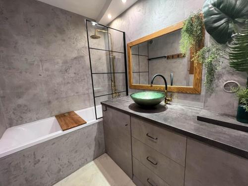 格但斯克Apartament Plaża 50的浴室配有盥洗盆、浴缸和盥洗盆