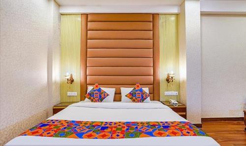 诺伊达FabHotel Prime Noida Sector 63的一间卧室配有一张大床和木制床头板