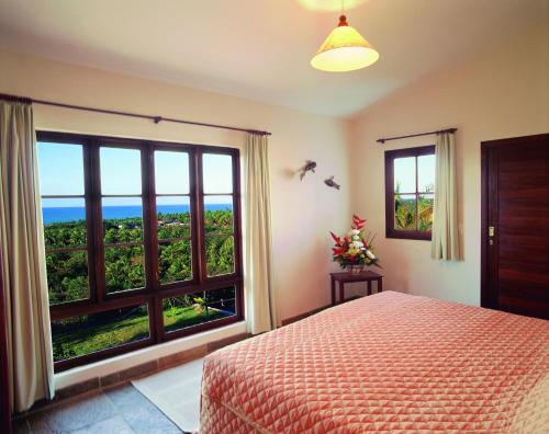 皮帕瓦兰达斯月德琵琶酒店的一间卧室设有一张床和一个大窗户