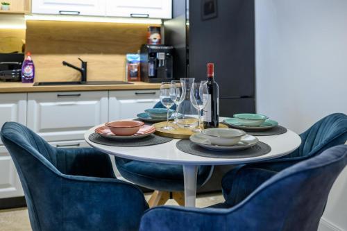 蒂米什瓦拉Five Stars Apartment的厨房里摆放着盘子和酒杯的桌子