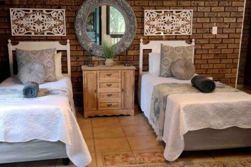玛洛斯帕克Stadigies Self-Catering Accommodation的一间卧室配有两张床和镜子