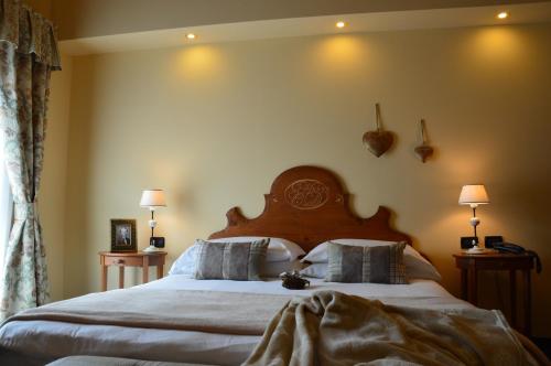 维哥迪法萨伽尼卡佩迪耶姆酒店的一间卧室配有一张大床和木制床头板