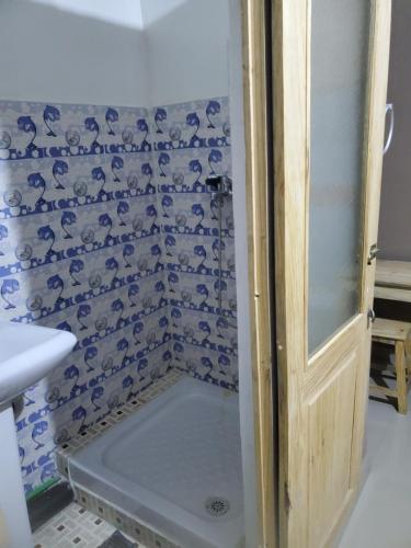 Ivato赫姆莱迪斯旅馆的浴室设有蓝色和白色瓷砖淋浴。