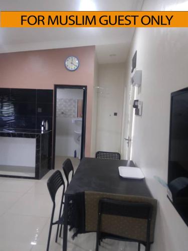 科亚Yasmeen Studio Roomstay Kijal - Room 1 - FOR TWO PERSON ISLAM GUEST ONLY的一间带桌椅和时钟的用餐室