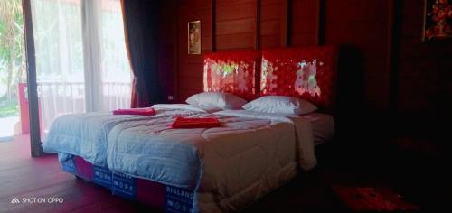 TapokrengRaflow Resort Raja Ampat的一间卧室配有一张红色床头板的床