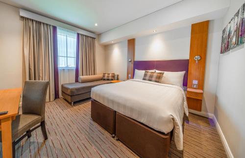 迪拜迪拜矽谷绿洲普瑞米尔酒店的配有一张床和一张书桌的酒店客房
