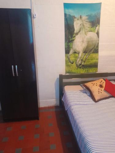 亚特兰蒂斯达Posada atlantida的卧室配有一张床,并画有一幅马