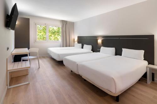 鲁维B&B HOTEL Barcelona Rubí的酒店客房设有两张床和电视。