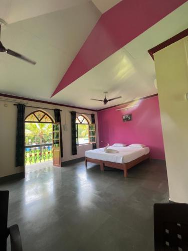 Green valley jungle resort的一间卧室配有一张床和粉红色的墙壁