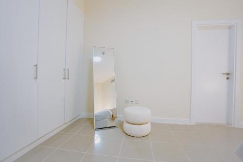 迪拜Citi home 1BR New Marina Sulafa Tower的白色的房间,配有凳子和镜子