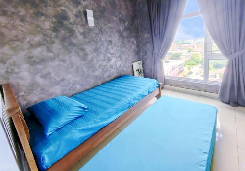 Kota BharuSkyHome @ D'Perdana Kota Bharu的窗户客房内的一张带蓝色床单的床
