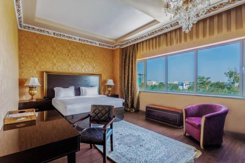 塔什干达尔罕精品酒店的酒店客房配有一张床、一张桌子和一把椅子。