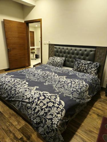 拉瓦尔品第Aesthetic Scenic Luxurious Apartment - Bahria Heights的一间卧室配有一张带黑白色棉被的床