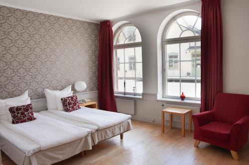 埃斯基尔斯蒂纳克拉利奥伯林徳蒙特尔连锁酒店的酒店客房,设有两张床和一张红色椅子