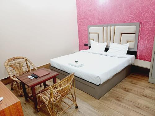 Rāni PokhriParadise Home stay的卧室配有一张床和一张桌子及椅子