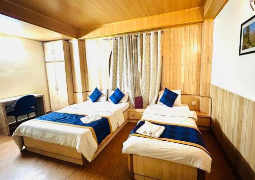 甘托克Dhe Kyi Khang by Magwave Hotels-100 Mts from MG Marg的一间卧室设有两张床和窗户。