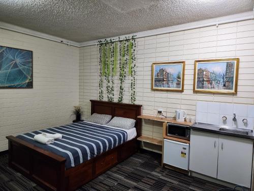 阿德莱德West End Motel的一间卧室配有一张床和一个水槽