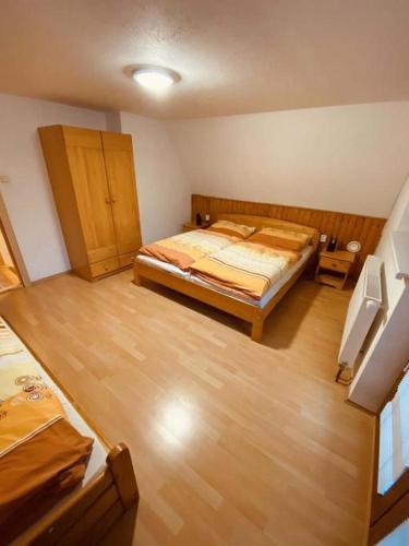 顺佩尔克Chata u Sněženky的一间卧室配有一张床,铺有木地板